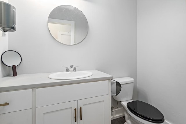 half bathroom with vanity and toilet