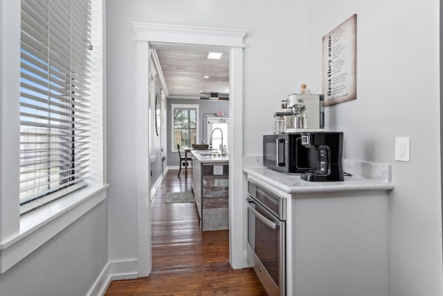 interior space featuring baseboards, dark wood-style floors, and a sink