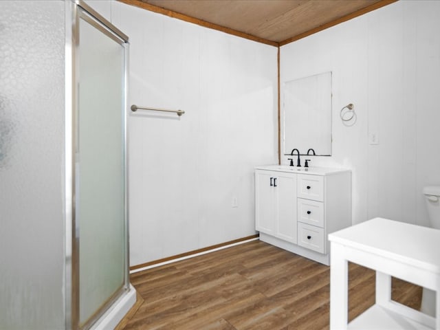 bathroom featuring toilet, wood finished floors, vanity, and a shower stall