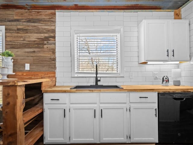 kitchen with dishwasher, butcher block counters, a sink, and white cabinetry