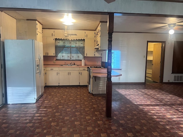 602 Devereaux, Diboll, TX 75941 - kitchen featuring white refrigerator with ice dispenser, a sink, ceiling fan, stainless steel gas range oven, and white cabinets