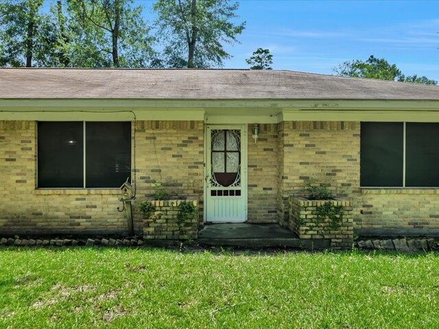 602 Devereaux, Diboll, TX 75941 - property entrance featuring brick siding and a lawn