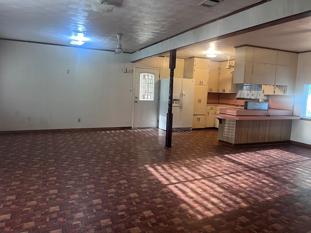 602 Devereaux, Diboll, TX 75941 - kitchen featuring white refrigerator with ice dispenser, a peninsula, baseboards, and white cabinetry