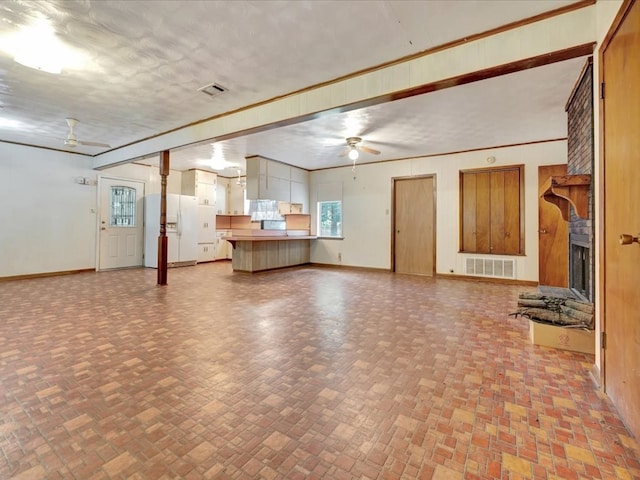 602 Devereaux, Diboll, TX 75941 - unfurnished living room featuring ceiling fan, a large fireplace, and brick patterned floors