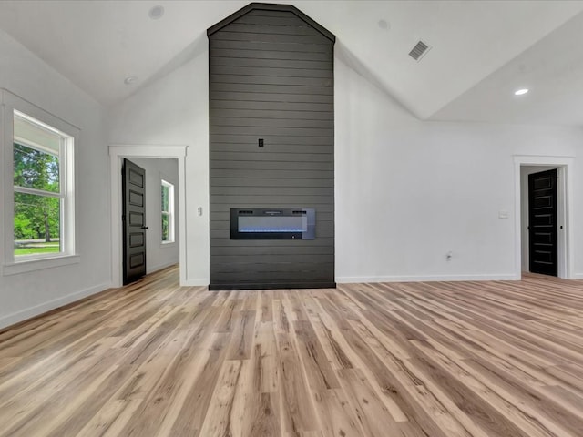 1920 Fm 842, Lufkin, TX 75901 - unfurnished living room featuring a fireplace, light wood-style flooring, and high vaulted ceiling