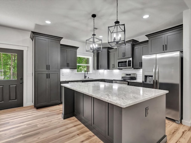1920 Fm 842, Lufkin, TX 75901 - kitchen with stainless steel appliances, a chandelier, a center island, tasteful backsplash, and light stone countertops