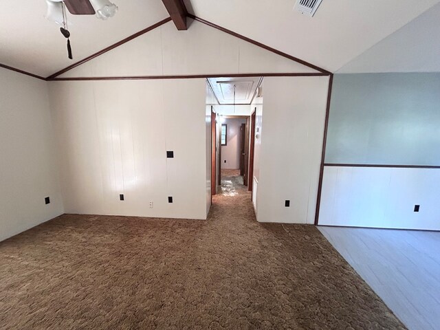 carpeted empty room with attic access, visible vents, crown molding, and lofted ceiling with beams