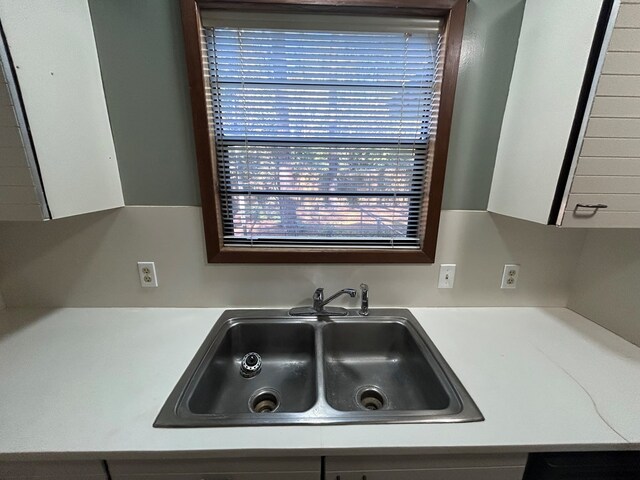 kitchen with white cabinets, light countertops, and a sink