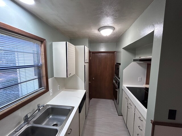 kitchen with extractor fan, a sink, white cabinetry, light countertops, and appliances with stainless steel finishes