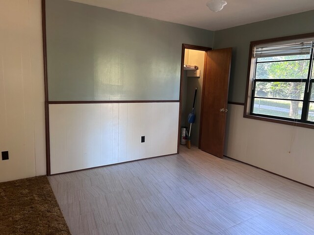 spare room with a wainscoted wall