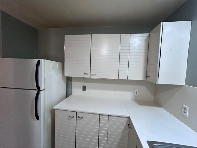 kitchen with light countertops and freestanding refrigerator