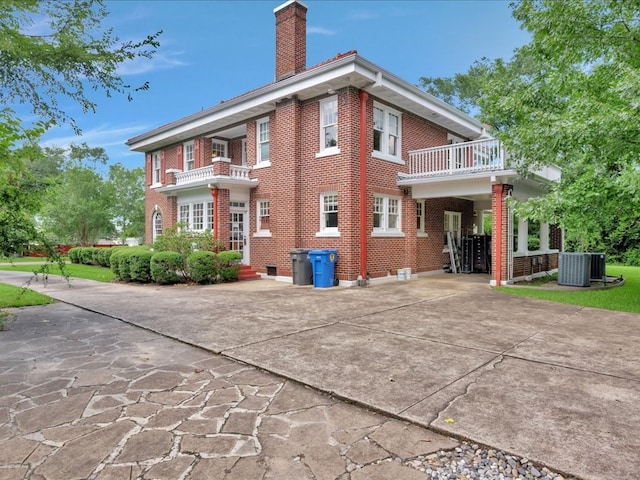 107 W Kerr Ave, Lufkin, TX 74904 - rear view of house featuring a balcony, a chimney, and brick siding
