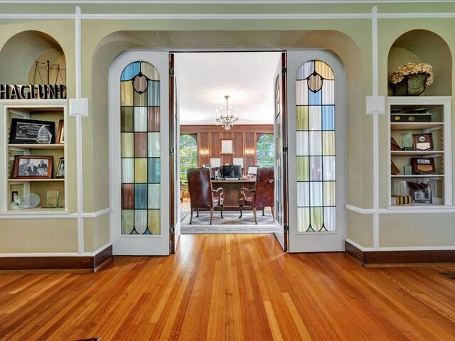 107 W Kerr Ave, Lufkin, TX 74904 - entryway featuring wood finished floors, built in shelves, and a chandelier