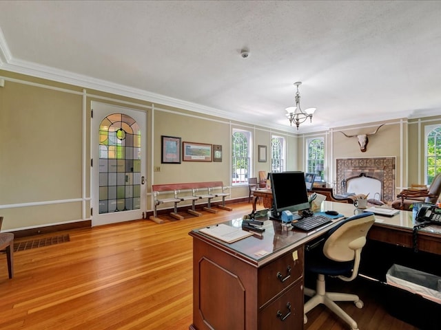 107 W Kerr Ave, Lufkin, TX 74904 - office area featuring crown molding, a chandelier, a fireplace, and light wood-style floors