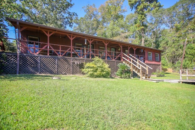 back of house with a lawn, stairway, and a porch