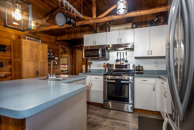 kitchen featuring a sink, lofted ceiling with beams, wood ceiling, appliances with stainless steel finishes, and under cabinet range hood