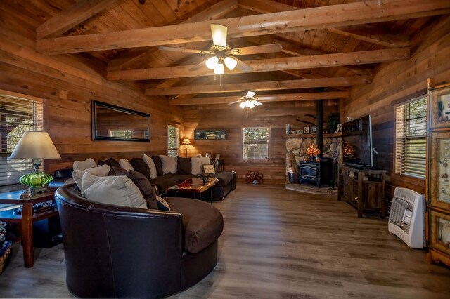 living area featuring wood ceiling, heating unit, wooden walls, and a wood stove