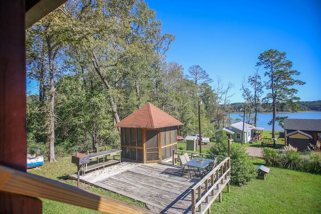 wooden terrace with a yard, outdoor dining space, and a water view
