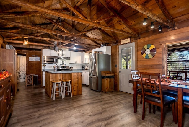 dining room with a healthy amount of sunlight, wood walls, and wooden ceiling