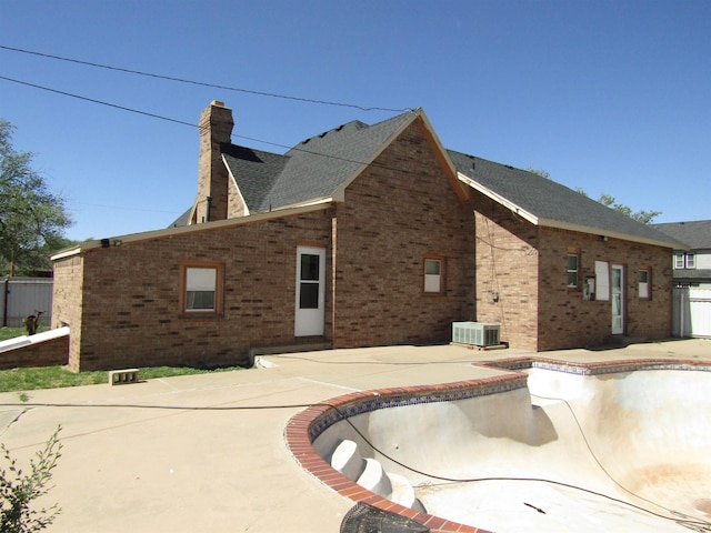 view of side of home featuring central AC, a patio area, and an empty pool