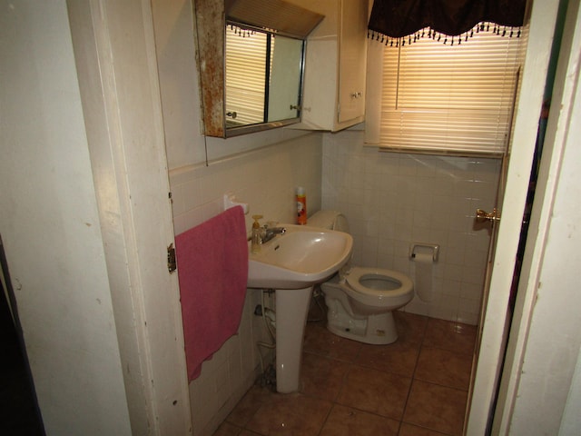 bathroom featuring tile patterned flooring, toilet, and tile walls