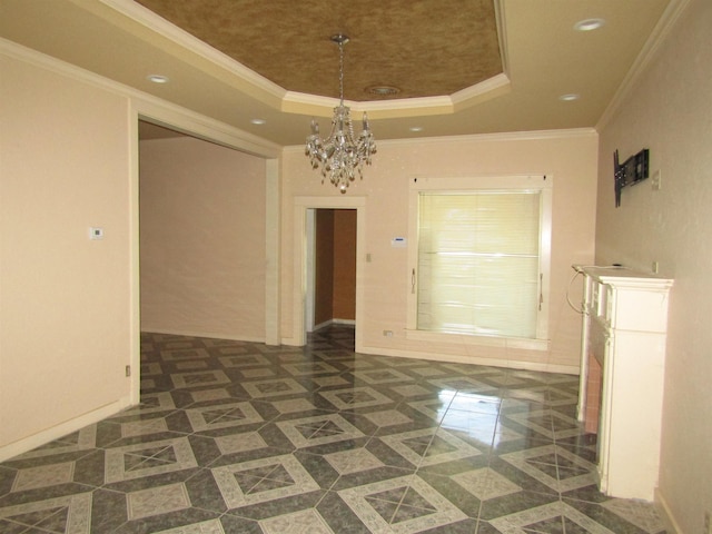 unfurnished dining area with a tray ceiling, an inviting chandelier, dark tile patterned floors, and ornamental molding