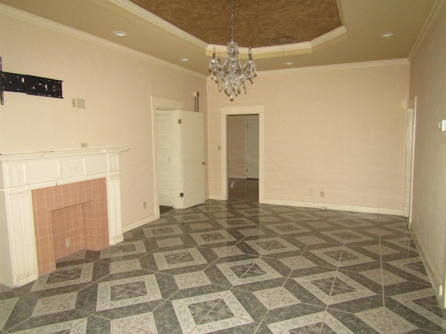 interior space with a raised ceiling, a tiled fireplace, crown molding, and a chandelier