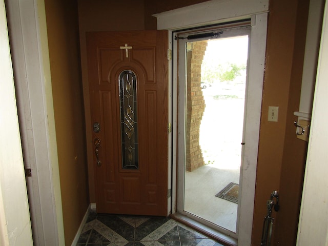 doorway to outside featuring dark tile patterned floors