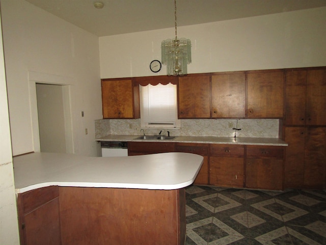 kitchen featuring sink, hanging light fixtures, backsplash, kitchen peninsula, and white dishwasher