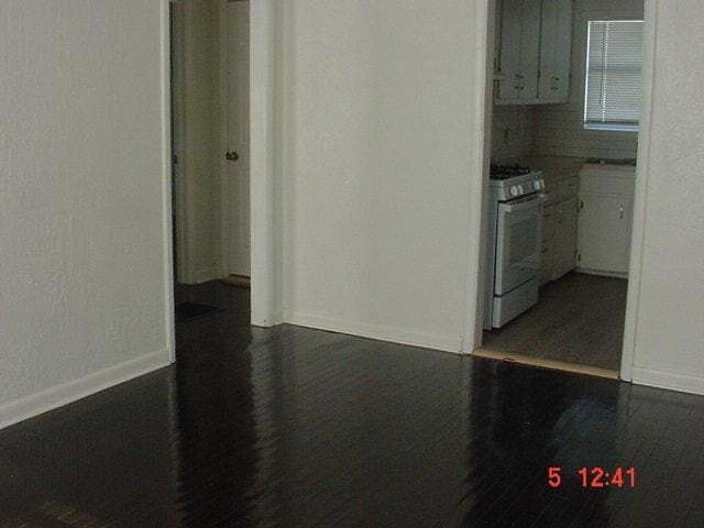 kitchen featuring white cabinets, decorative backsplash, and white range with gas cooktop