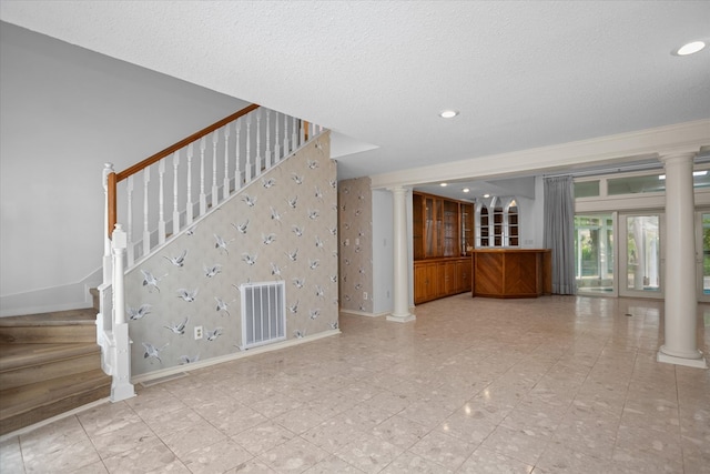 109 Innisbrook Dr, Lufkin, TX 75901 - unfurnished living room with decorative columns, stairway, baseboards, recessed lighting, and a textured ceiling