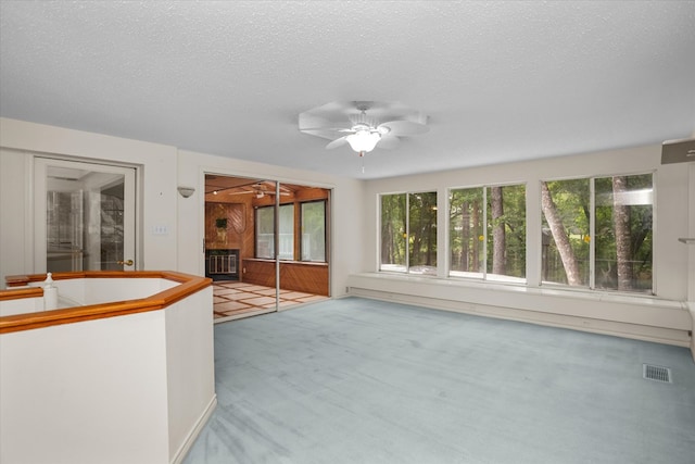 109 Innisbrook Dr, Lufkin, TX 75901 - unfurnished living room with ceiling fan, carpet flooring, a glass covered fireplace, and a textured ceiling