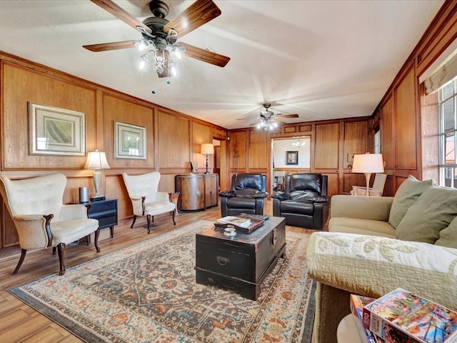 128 Tamie Lowe Rd, Moscow, TX 75960 - living room featuring a ceiling fan, wood walls, light wood finished floors, and crown molding