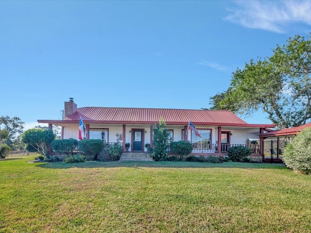 128 Tamie Lowe Rd, Moscow, TX 75960 - ranch-style home featuring a chimney, a porch, a front lawn, and metal roof