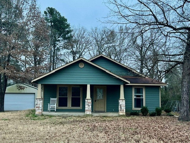 view of front of home featuring a porch, a garage, and an outdoor structure