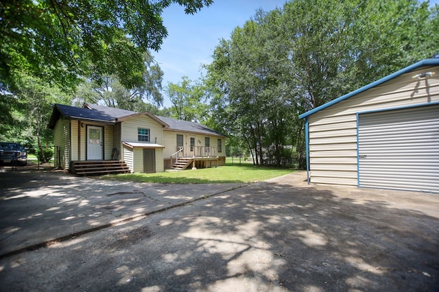 213 Lee Ln, Lufkin, TX 75904 - view of front of house with asphalt driveway, an outbuilding, a front lawn, and a wooden deck