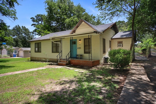 213 Lee Ln, Lufkin, TX 75904 - bungalow featuring a front yard, a porch, a detached garage, and a shingled roof
