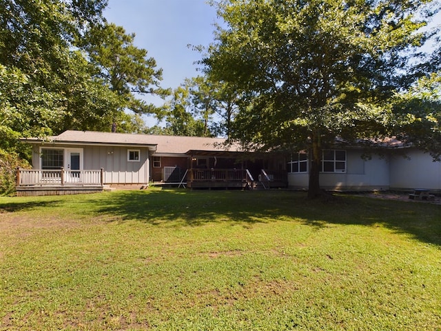 back of property featuring a lawn and a deck