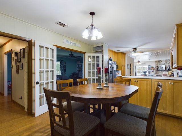 dining room featuring a chandelier, light hardwood / wood-style floors, and crown molding