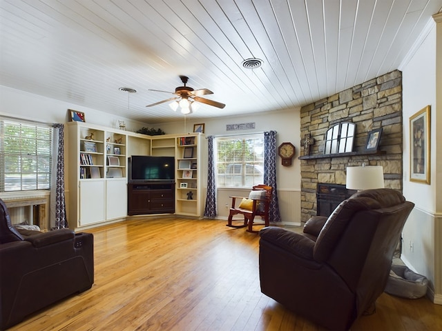 living room with wooden ceiling, light hardwood / wood-style flooring, ceiling fan, ornamental molding, and a fireplace