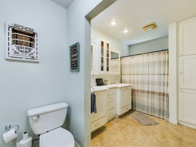 bathroom with tile patterned flooring, vanity, curtained shower, and toilet