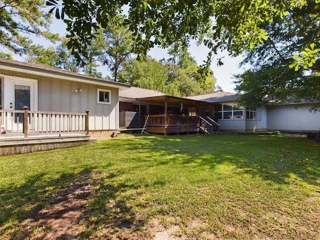 back of house with central air condition unit, a wooden deck, and a lawn