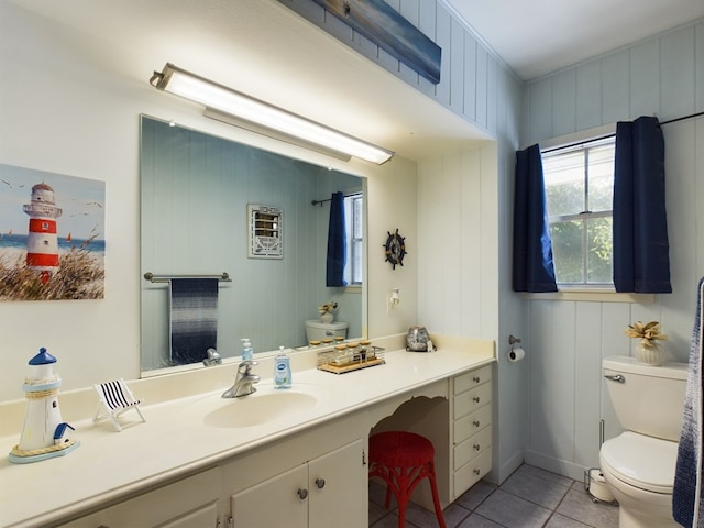 bathroom with wood walls, tile patterned flooring, vanity, and toilet