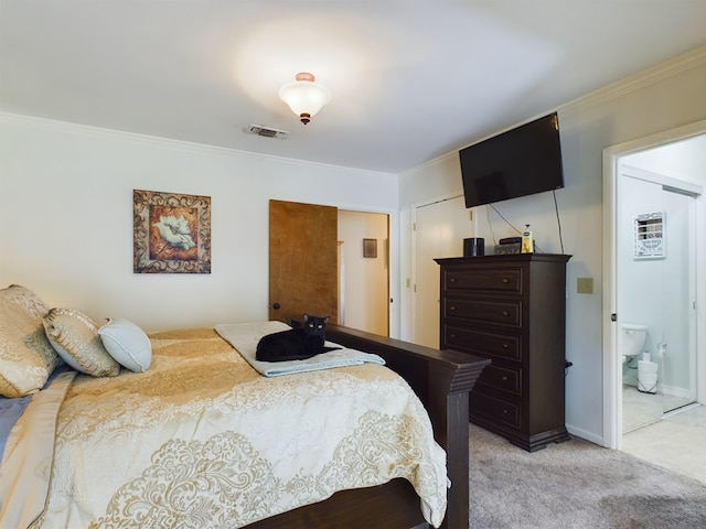 carpeted bedroom with a closet, crown molding, and ensuite bath