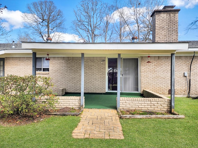 entrance to property with a lawn and a chimney