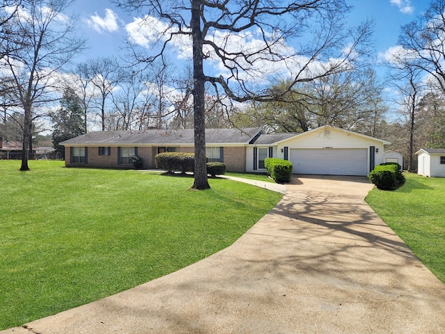 ranch-style home featuring brick siding, concrete driveway, a front yard, a garage, and a storage unit