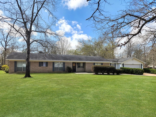 ranch-style home with a front yard, an attached garage, and brick siding