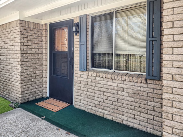 doorway to property with brick siding