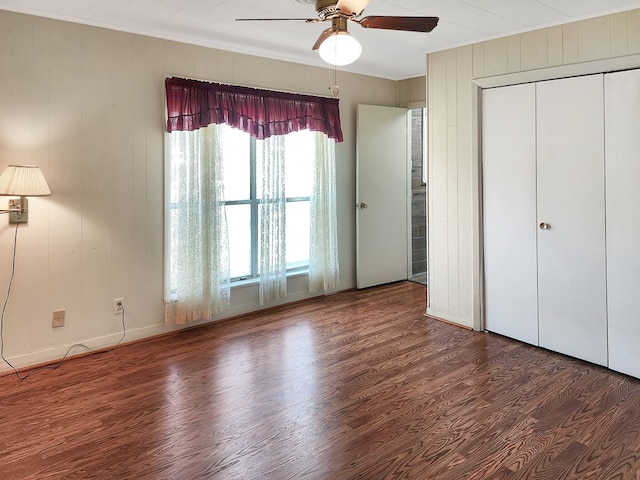 unfurnished bedroom with a closet, baseboards, ceiling fan, and wood finished floors