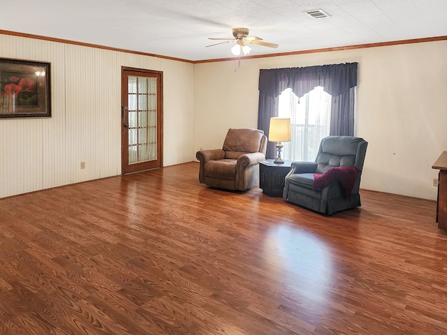 sitting room featuring visible vents, wood finished floors, a ceiling fan, and ornamental molding